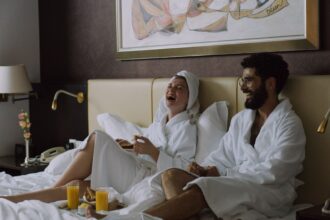 Kuvassa pariskunta hotellissa huoneaamiaisella. Kuvituskuva