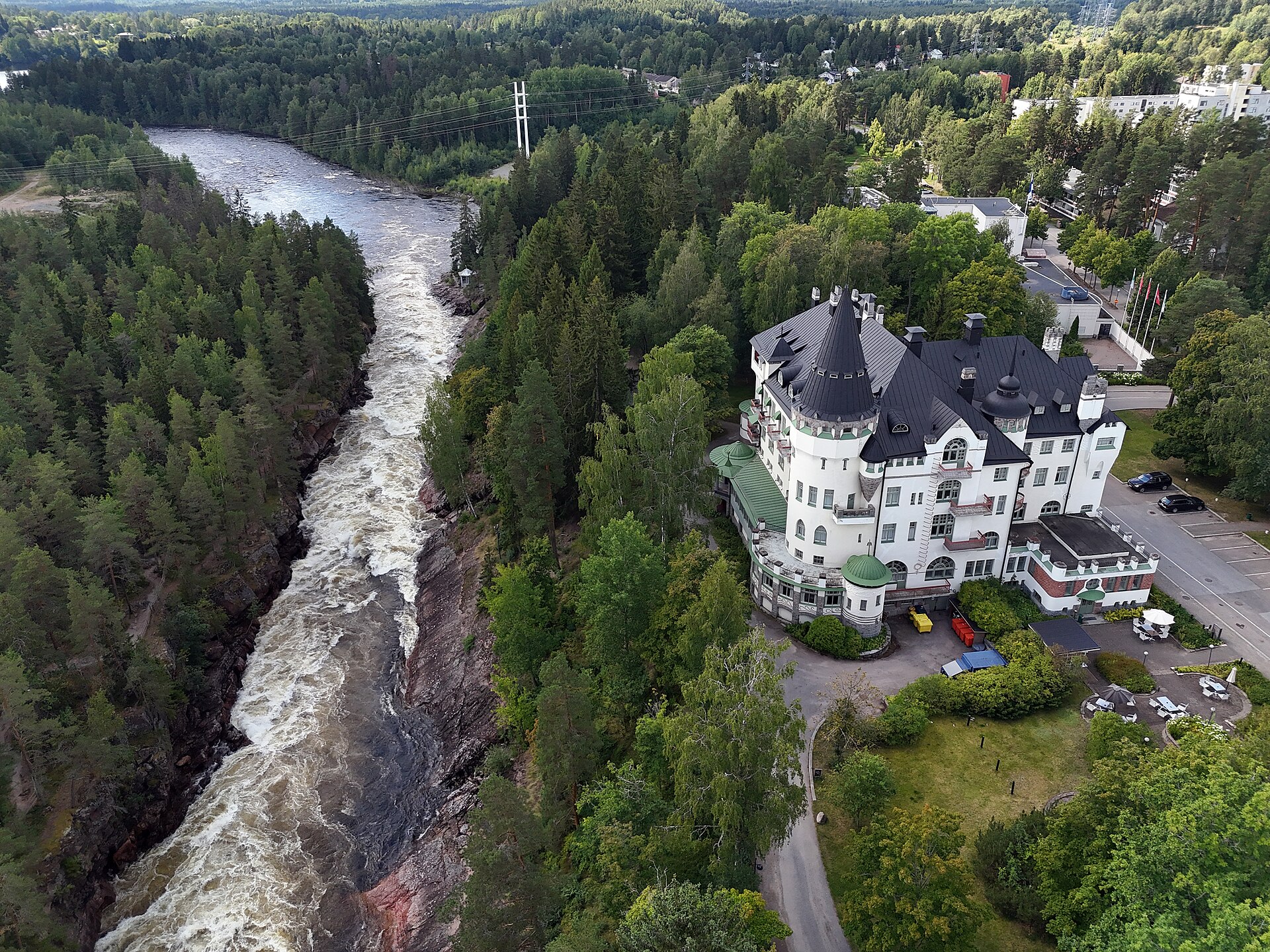 Ilmakuva Imatrankoskesta ja Imatran Valtionhotellista. Kosken kuohuva uoma kulkee metsäisessä maisemassa historiallisen Valtionhotellin vieressä. Kuva: Teemu Mökkönen / Museovirasto, Kulttuuriympäristön kuvakokoelma Lisenssi: CC BY 4.0