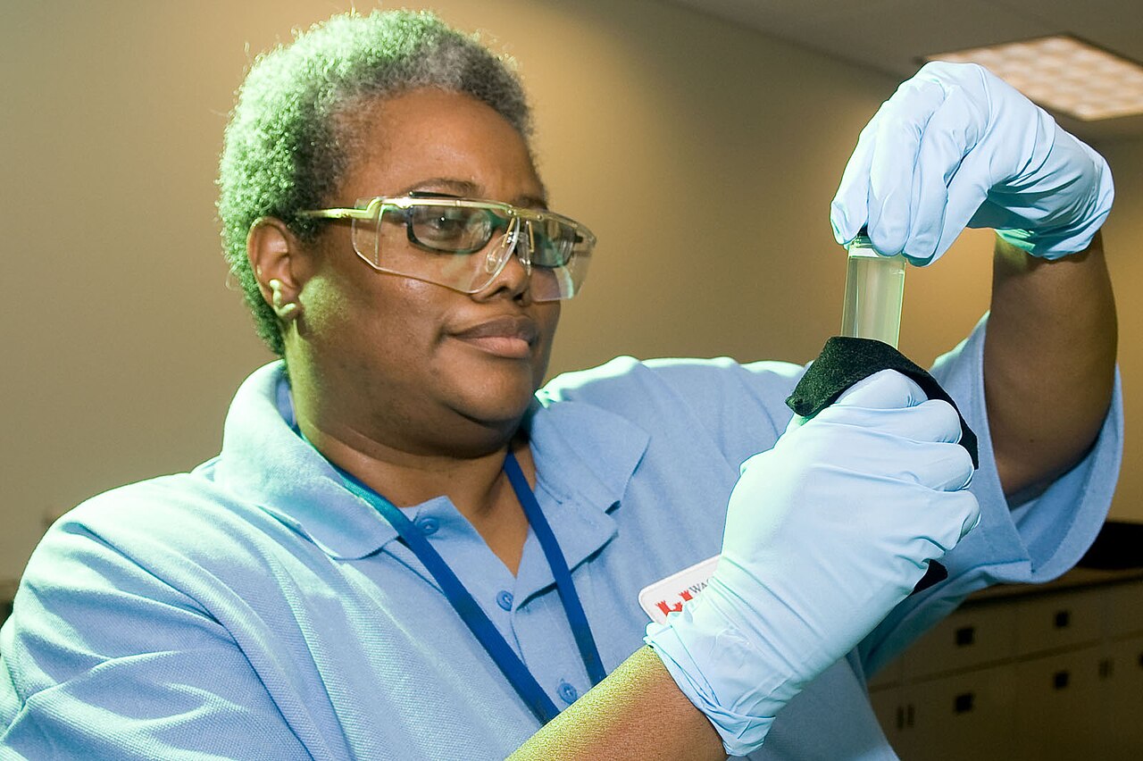 Tutkija tutkii vesinäytettä laboratoriossa suojalaseja ja suojakäsineitä käyttäen. Kuva: U.S. EPA / Wikimedia Commons (Public Domain). Kuvituskuva