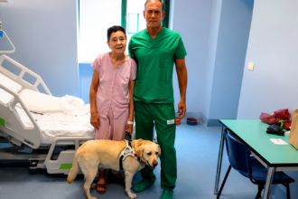 Elena, professori Michele Reibaldi ja opaskoira Joe Torinon Molinette-sairaalassa onnistuneen silmäleikkauksen jälkeen. Kuva: Città della Salute e della Scienza di Torino / Ospedale Molinette, Press Office