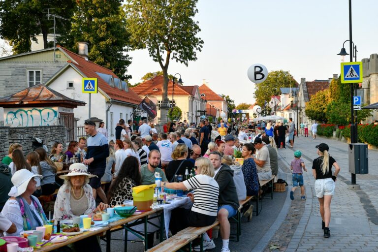 Pitkä pöytä koonnut erilaisia ihmisiä yhdessä syömään ja nauttimaan yhdessä olosta. Kuva: Margo Evardson/Unsplash