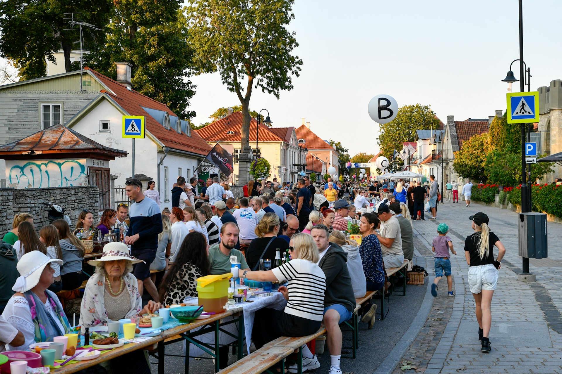 Pitkä pöytä koonnut erilaisia ihmisiä yhdessä syömään ja nauttimaan yhdessä olosta. Kuva: Margo Evardson/Unsplash