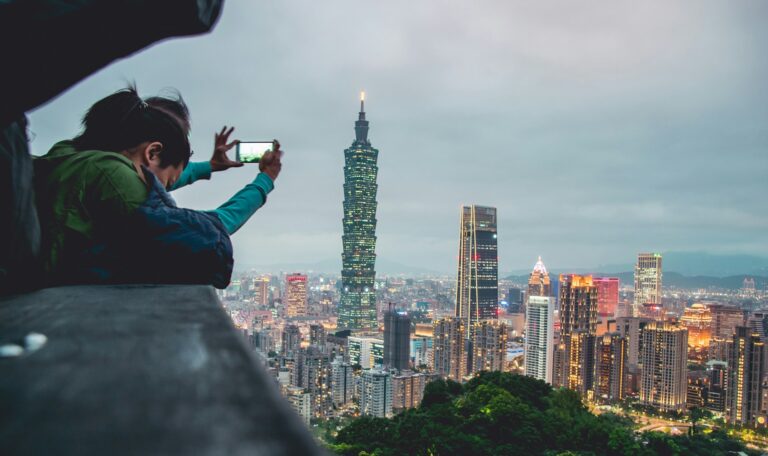Matkailija kuvaa Taipei 101 -pilvenpiirtäjää älypuhelimella Taiwanissa. Kuva: Vernon Raineil Cenzon/Unsplash