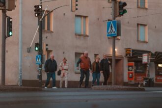 Ihmisiä ylittämässä katua Helsingissä loppukesän iltavalossa. Kuva: Jose Noel Marenco / Unsplash. Kuvituskuva
