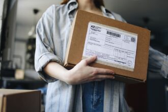 Kuriiri toimittaa ovelle paketin ja nainen ottaa sen vastaan. Kuva: Polina Tankilevitch/Pexels. Kuvituskuva