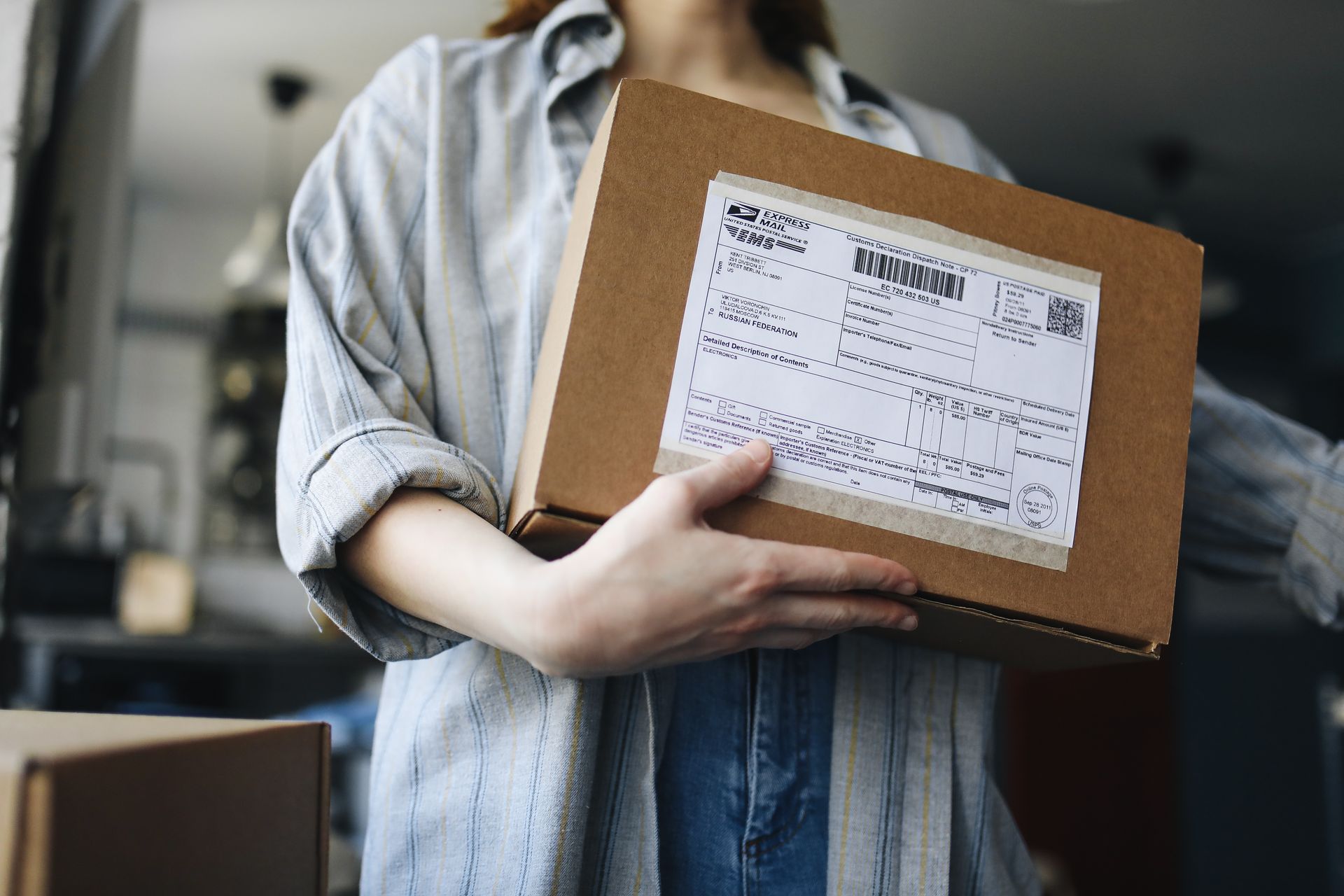Kuriiri toimittaa ovelle paketin ja nainen ottaa sen vastaan. Kuva: Polina Tankilevitch/Pexels. Kuvituskuva
