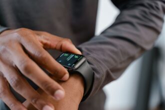 Mies katsoo älykelloaan joka näyttää eri tietoja. Kuva: Mart Production/Pexels