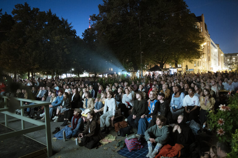 Suuri yleisö seuraa Karhupuisto Film Festivalin ulkoilmaelokuvanäytöstä iltahämärässä Helsingin Kalliossa. Kuva: Eero Liimatainen / Karhupuisto Film Festival