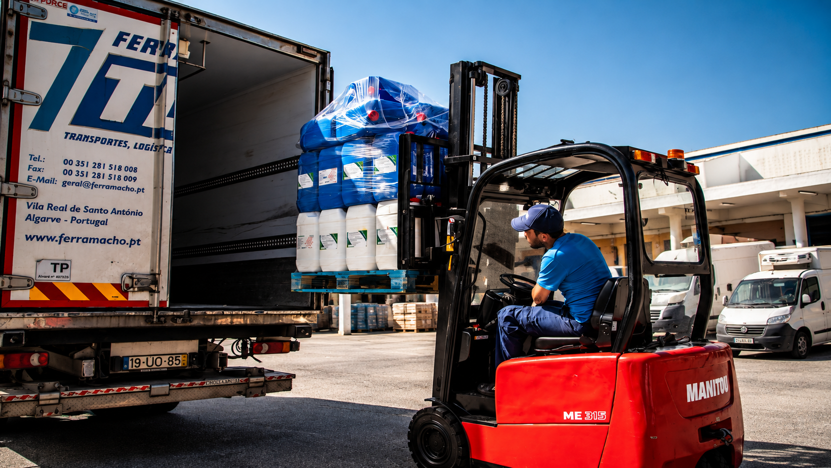 Trukki lastaa kuormalavoille pakattua tavaraa kuorma-autoon logistiikka-alueella.