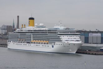 Costa Luminosa -risteilyalus Helsingin satamassa. Suuri valkoinen matkustaja-alus on kiinnittynyt laituriin risteilyterminaalin edustalle.