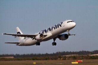 Finnairin valkoinen Airbus A321 -matkustajakone nousee Helsinki-Vantaan kiitotieltä laskutelineet vielä alhaalla.