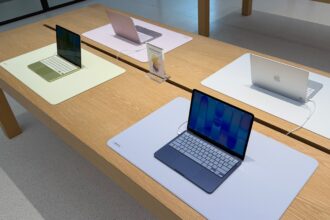 Useita Apple MacBook Neo -kannettavia tietokoneita esillä vierekkäin eri väreissä.