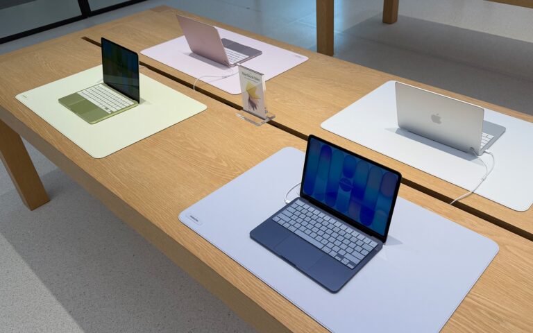 Useita Apple MacBook Neo -kannettavia tietokoneita esillä vierekkäin eri väreissä.